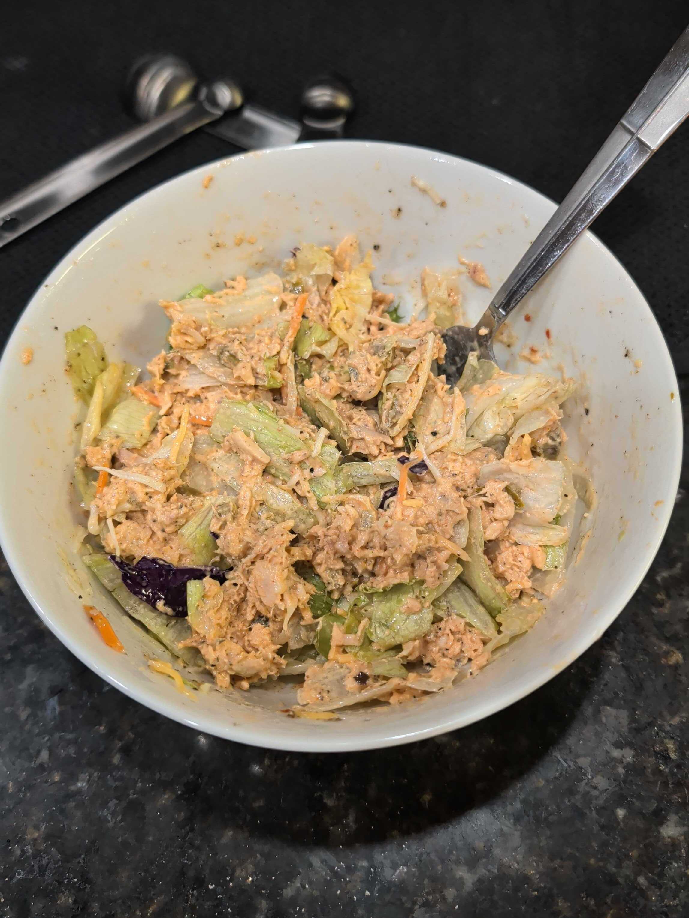 Extra-saucy Cajun tuna bowl over dressed greens with cheese